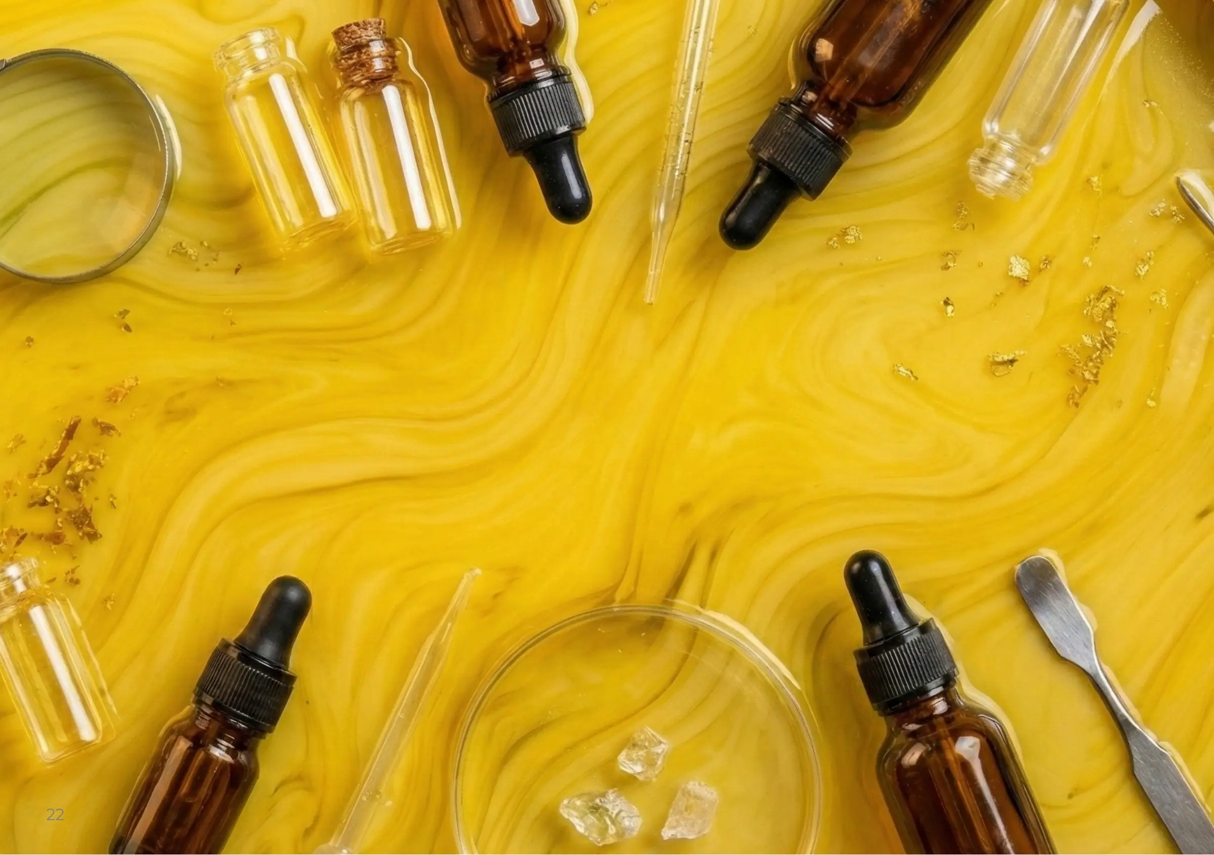 Glass droppers and pipettes on swirls of yellow